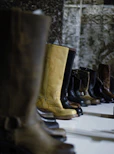 selective focus photography of boots beside wall