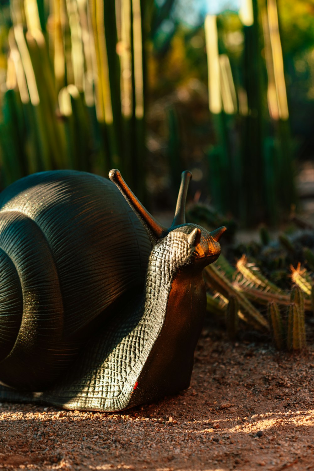 snail figure by plant during daytime