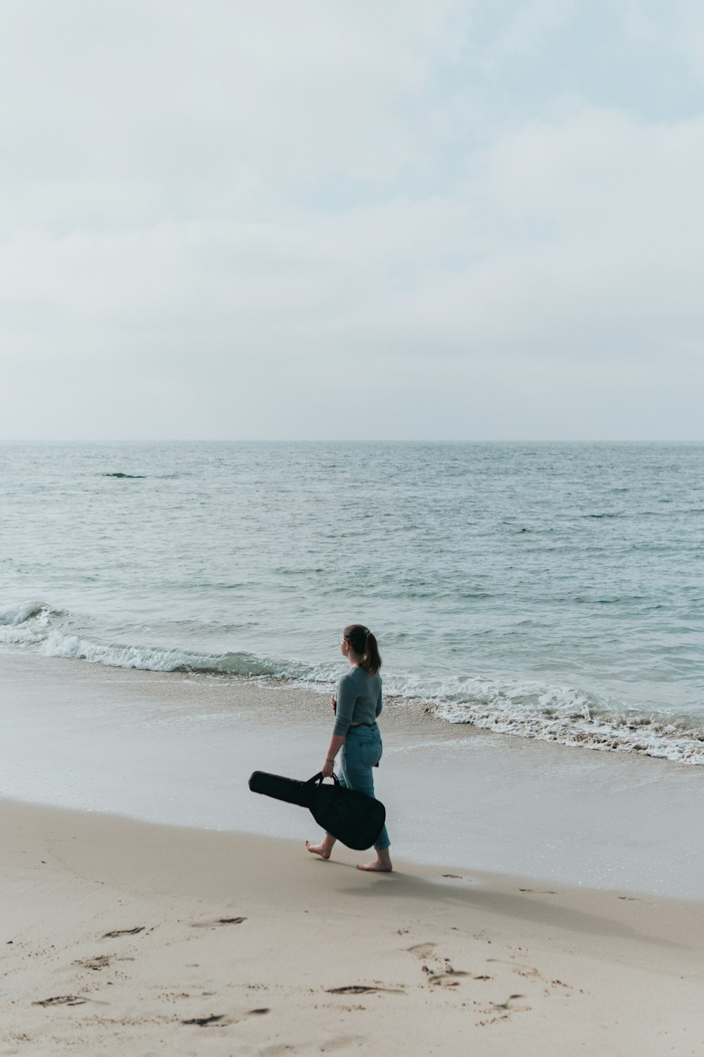 woman with gig bag at beach