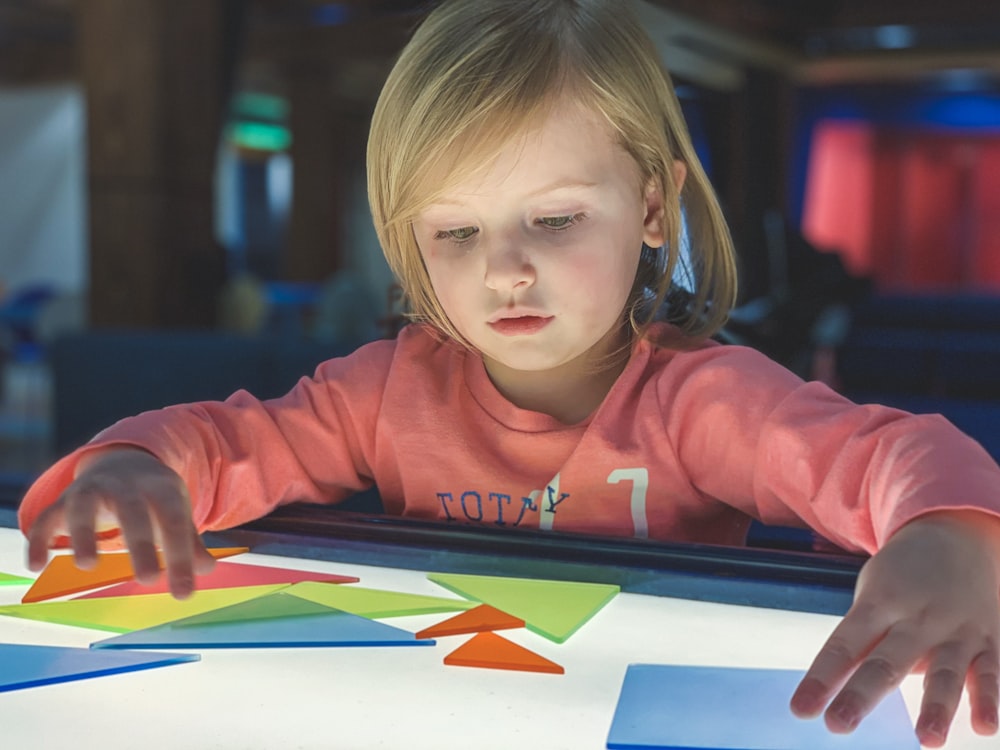 girl holding colored shapes