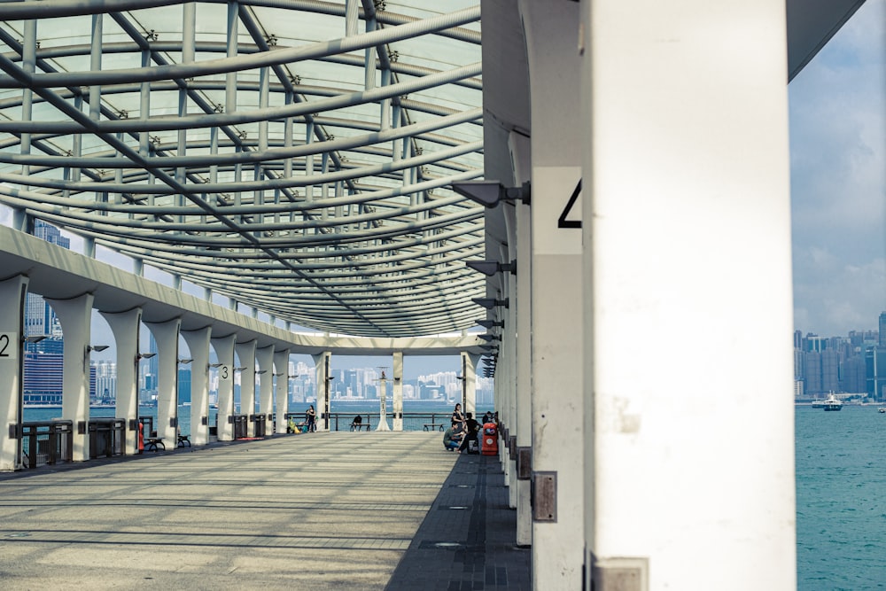 a walkway with a view of the water and a city in the background