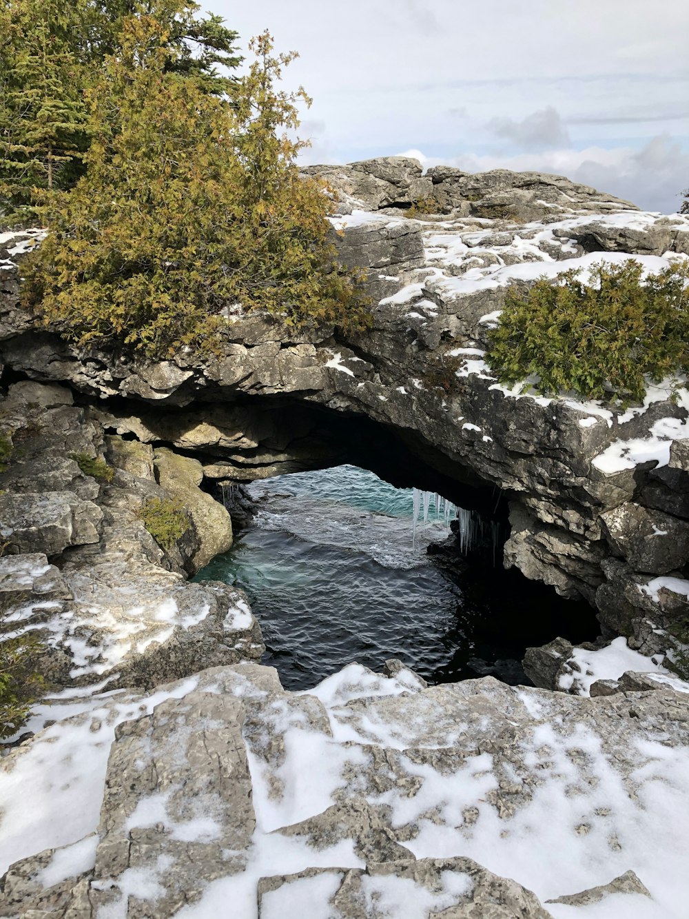 a small cave in the middle of a snowy mountain