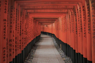 empty hallway between red-and-black Kanji posts