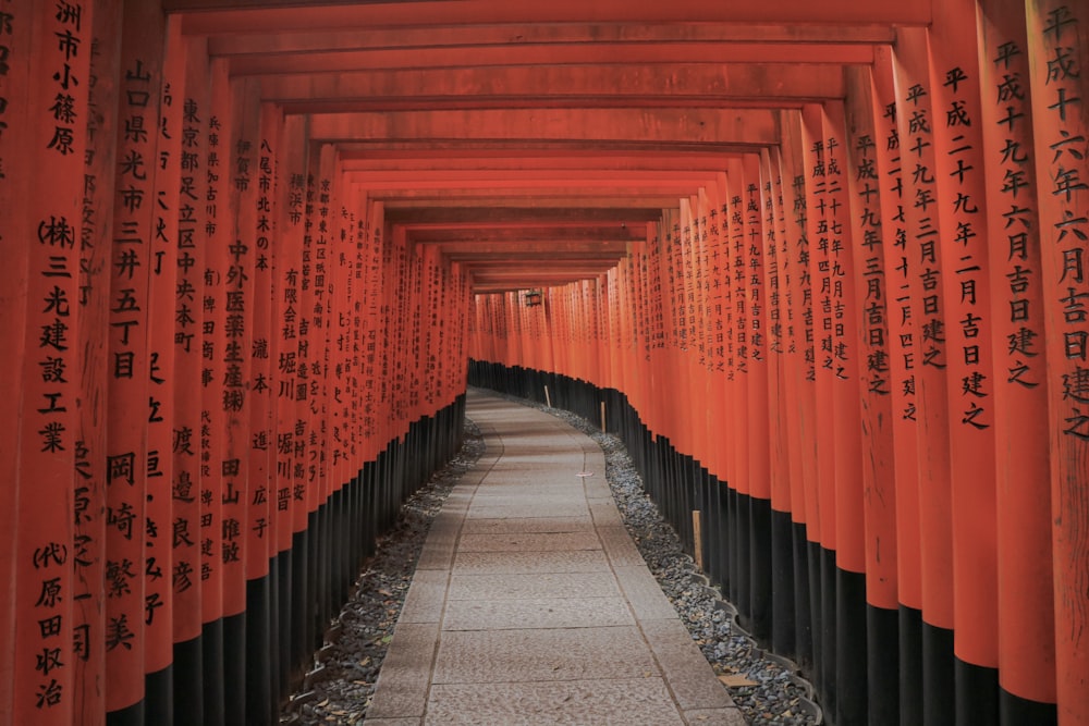 empty hallway between red-and-black Kanji posts
