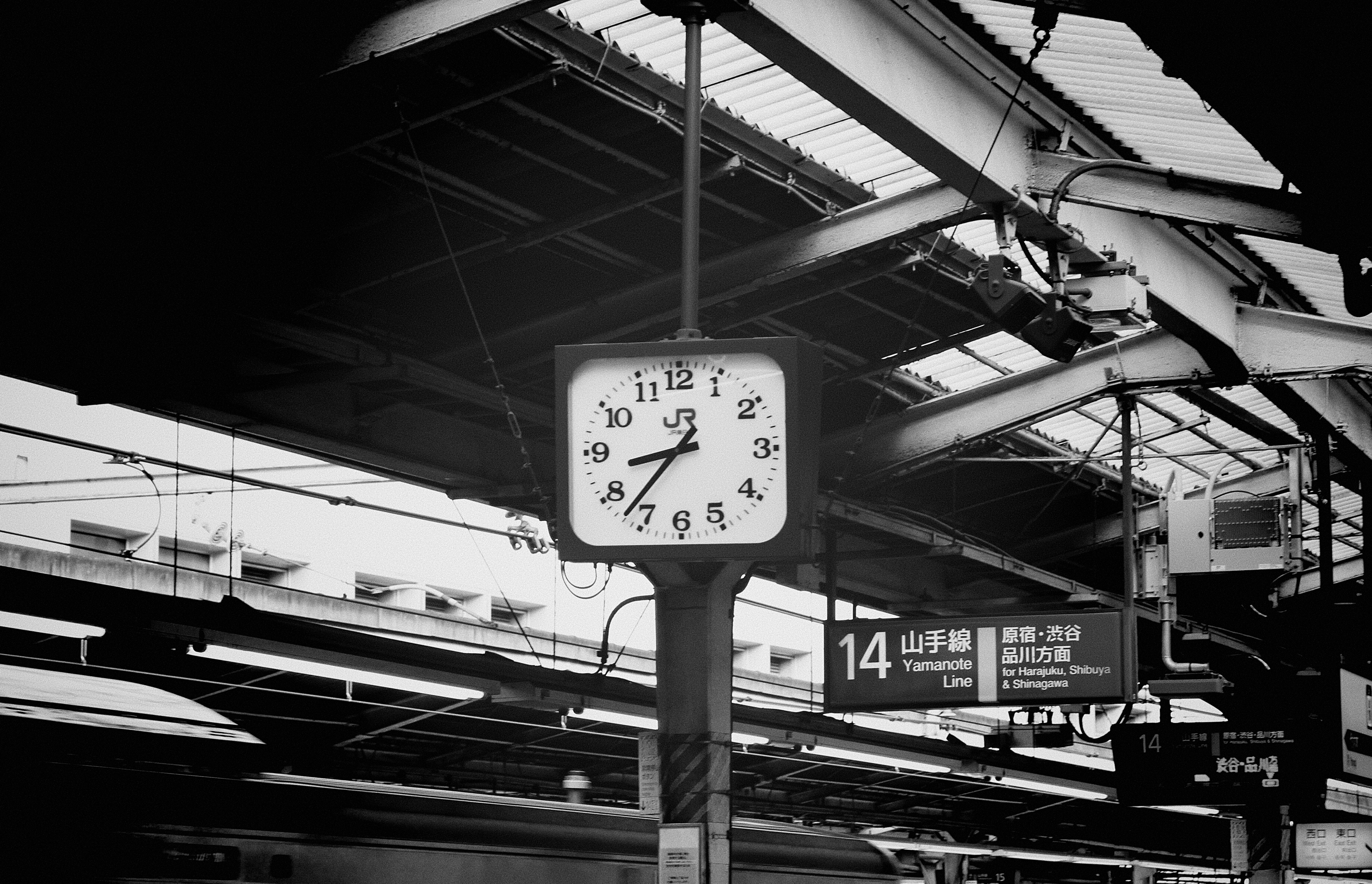 grayscale photography of train station with clock showing 08:37 time
