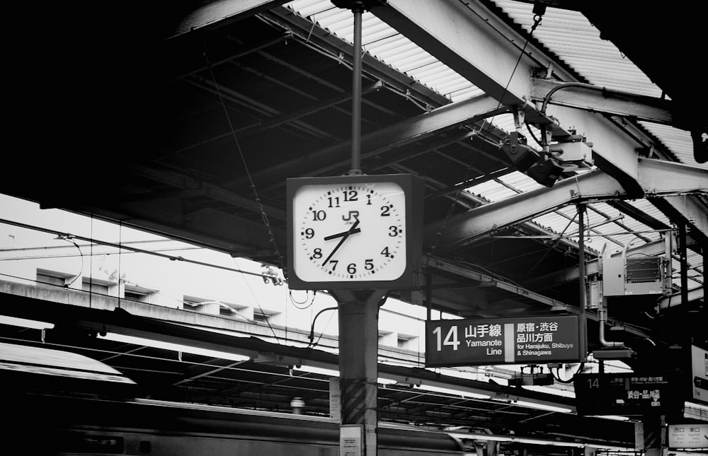 grayscale photography of train station with clock showing 08:37 time