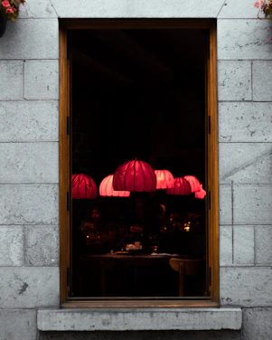 Dimly lit interior of noirflamme with sizzling steaks on the grill and a small stage for live musicians.