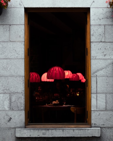 Cozy interior of Le Volpi restaurant with warm lantern beige lighting at sunset.