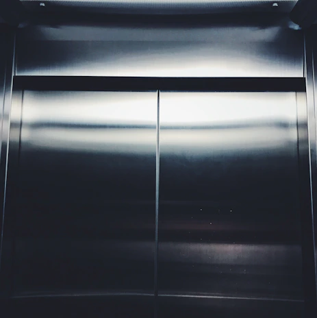 Modern elevator doors opening smoothly in a well-lit lobby.