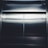 Smooth metallic elevator doors with a reflective surface, catching light at the top and bottom edges. The doors are centered and closed, with a dark seam running down the middle.