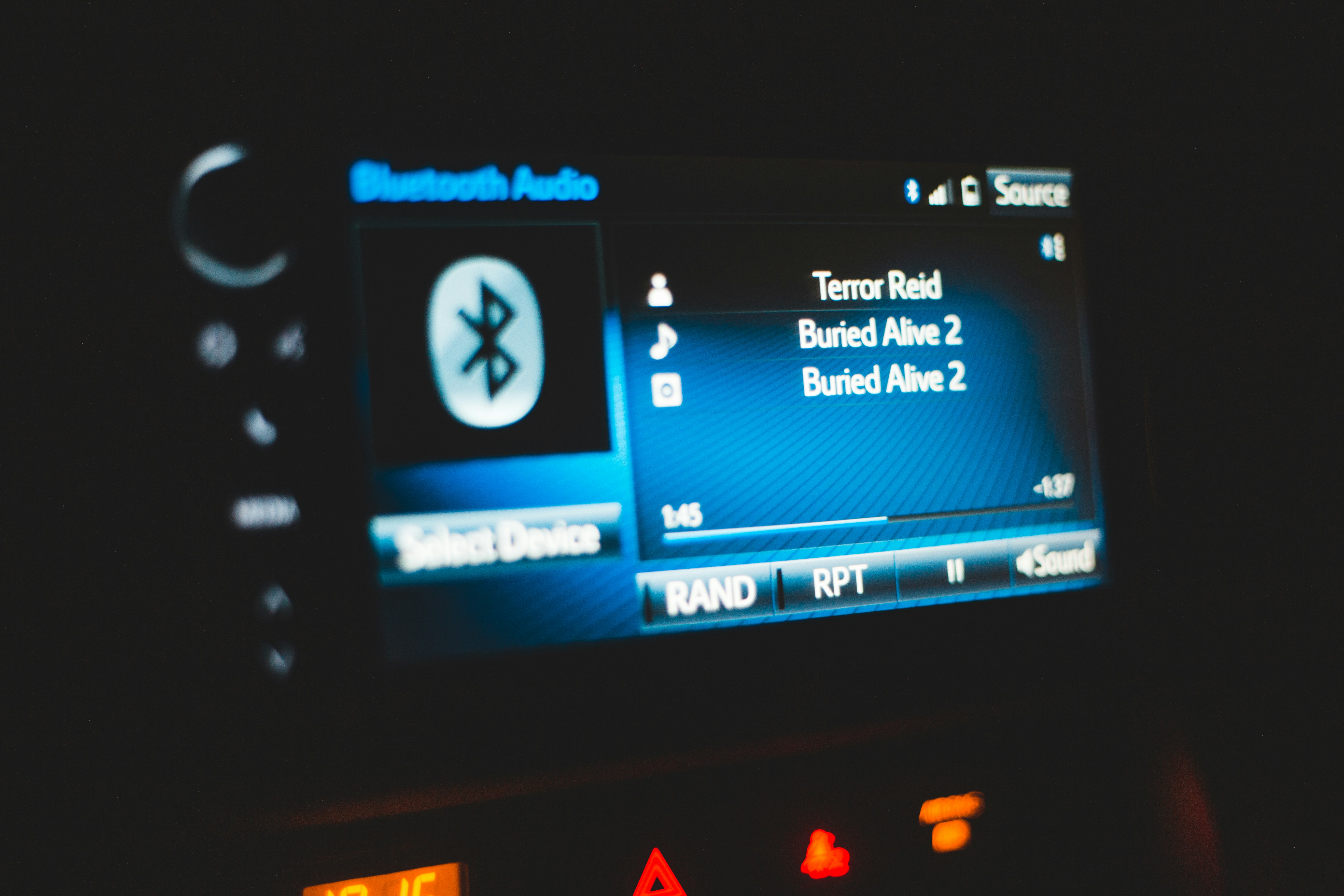 A close-up of a car audio screen showing Bluetooth audio, suggesting device confusion and control