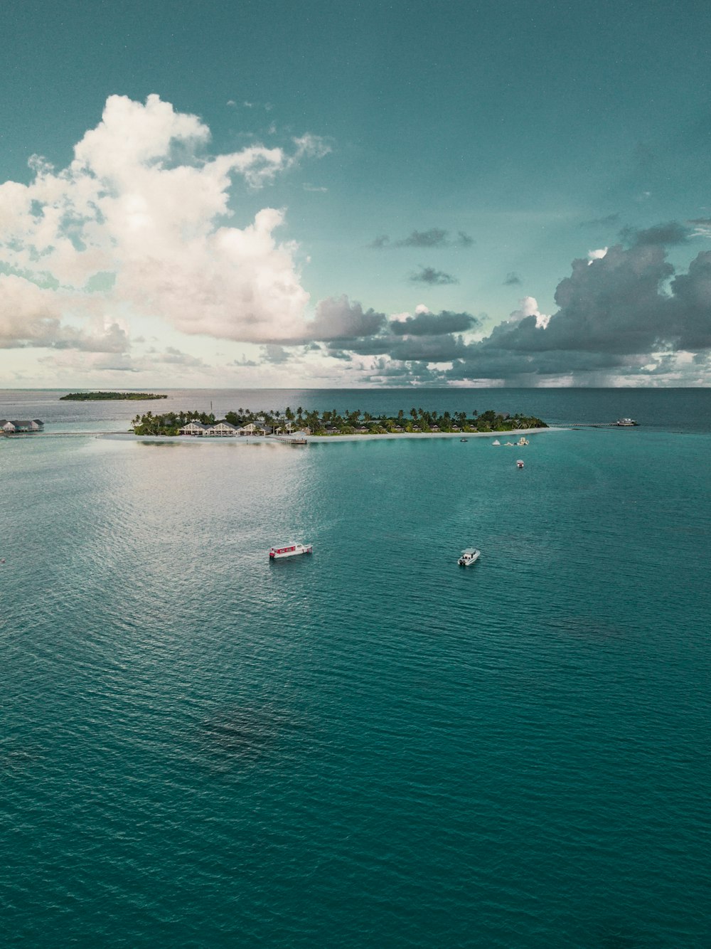 boats on sea near islet