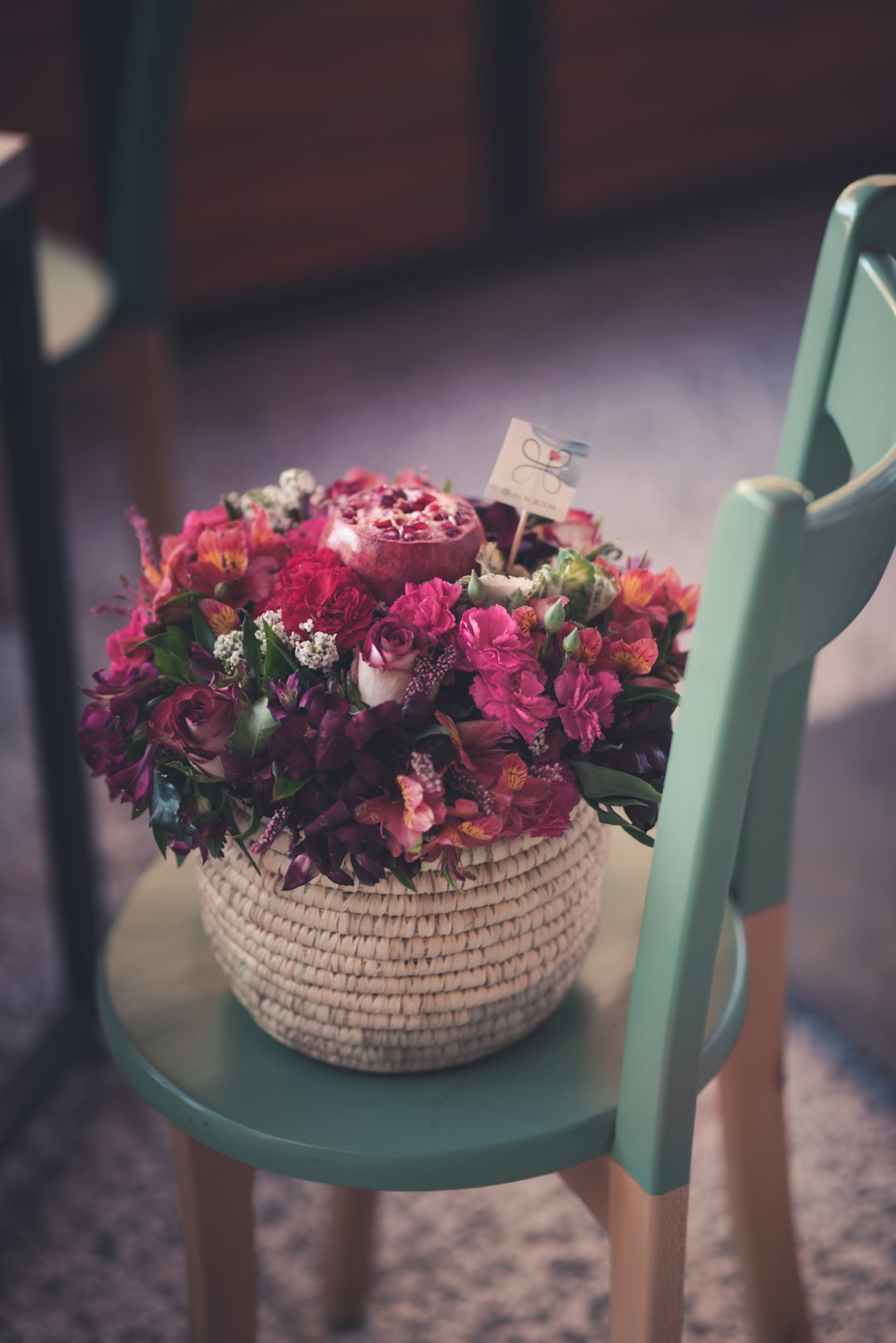 assorted-colored flowers in vase on green wooden chair