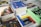 A collection of books and magazines is arranged on a table, including titles such as 'Design', 'bauhaus', 'Golden Age DC Comics', and a book with an 'Adults Only' label. The covers display bold colors and graphics, featuring a variety of subjects from comics to architecture.