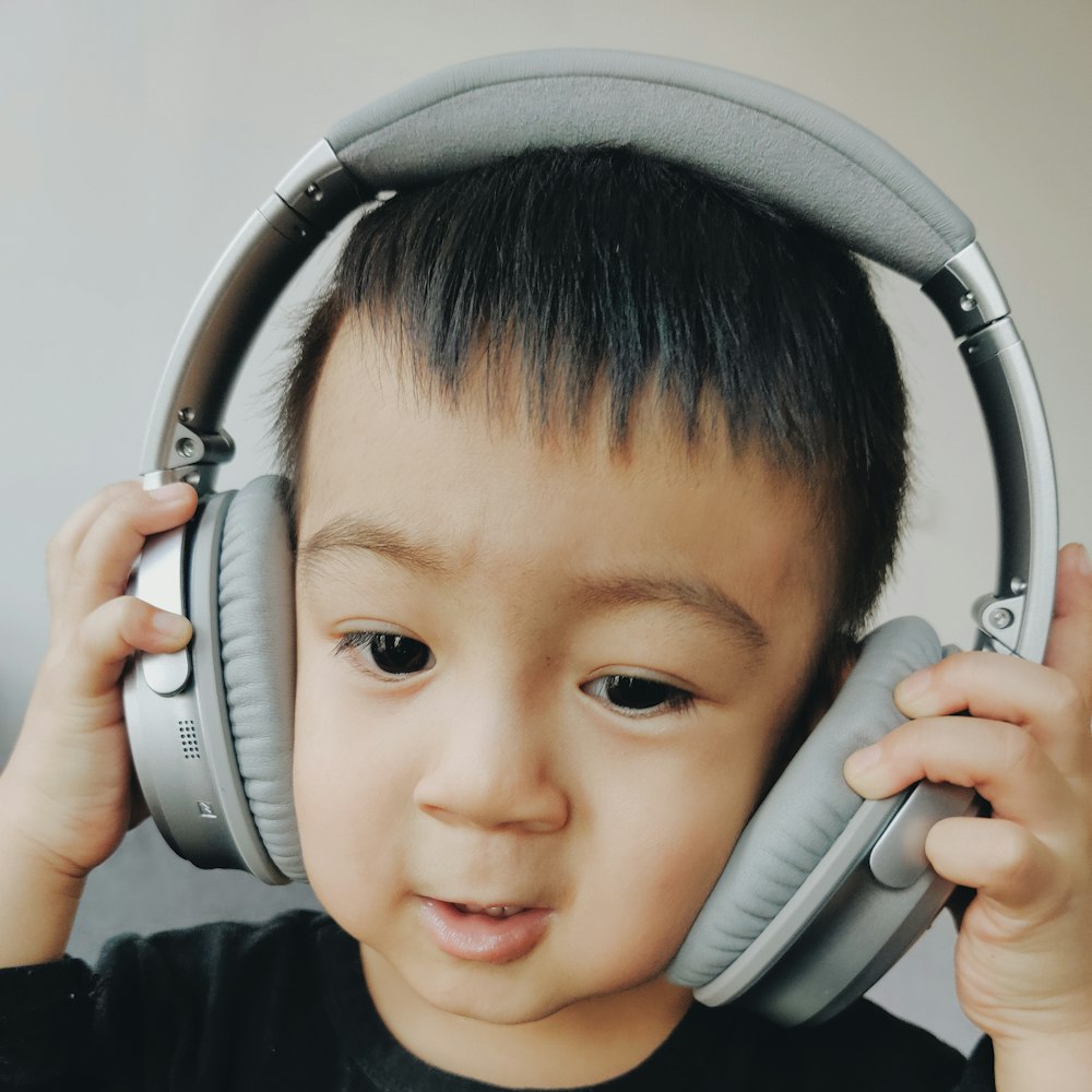 boy wearing grey cordless headphone