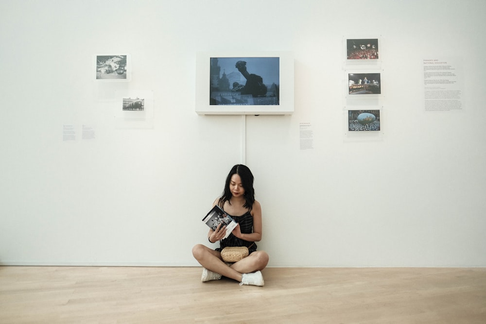 woman sitting near wall and monitor inside room