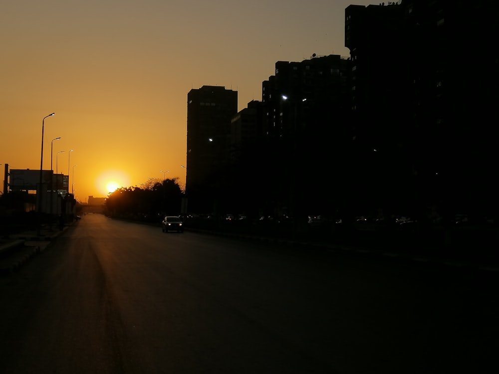 black vehicle on road near high-rise buildings during night time