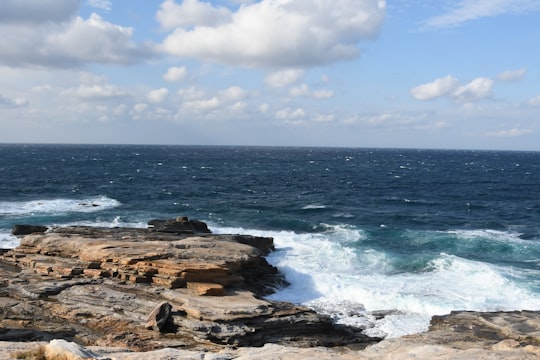 view photography of sea and stone shore under cloudy sky in Shirahama Japan