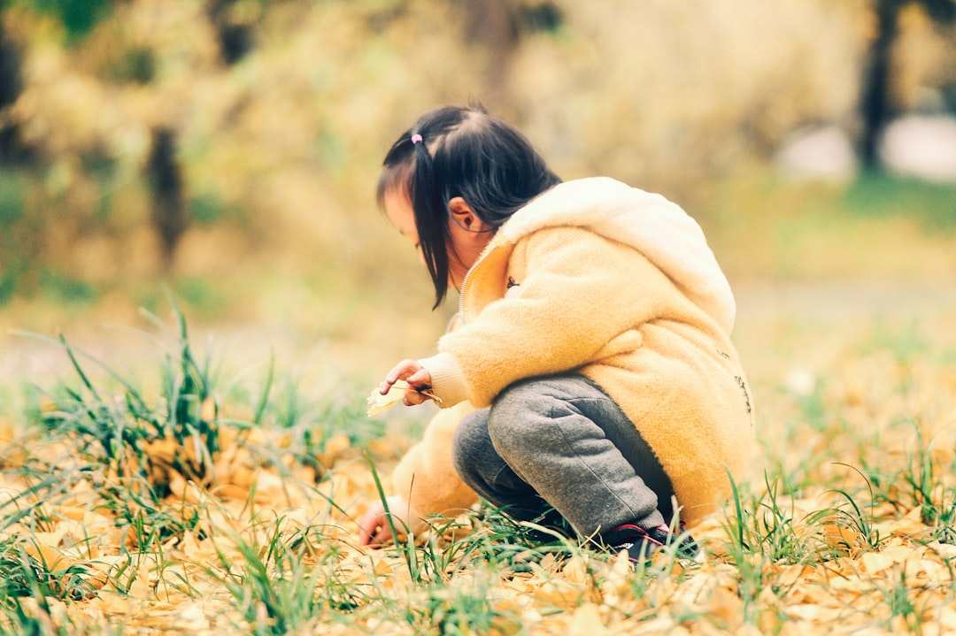 girl holding grass during daytime
