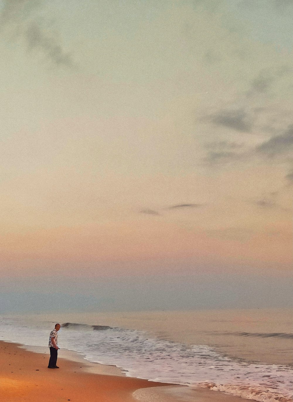 man standing on seashore during day