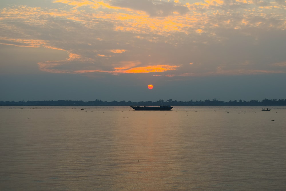 boat in calm body of water during golden hour