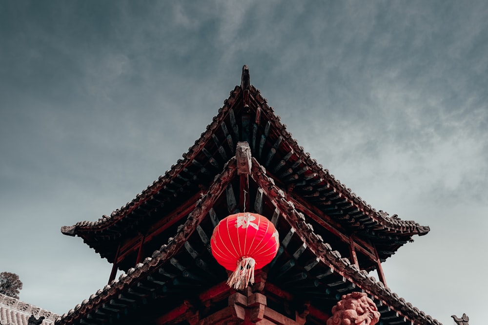 a chinese building with a red lantern hanging from it's roof