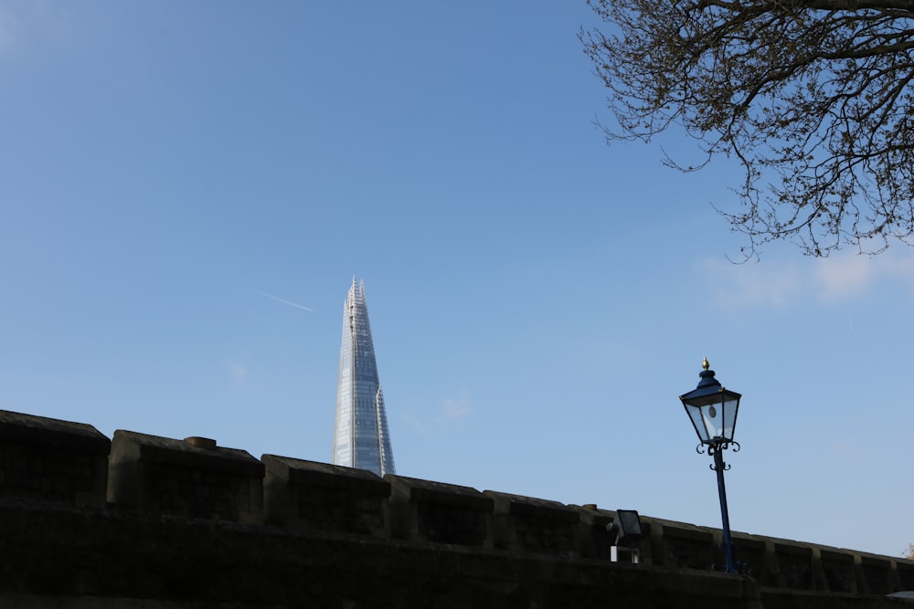 view of building's top through brick wall under blue sky