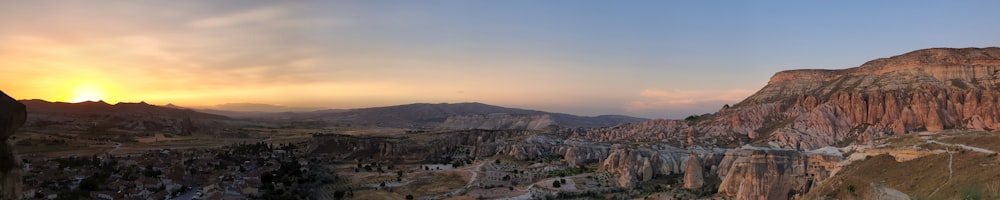 the sun is setting over a mountain range