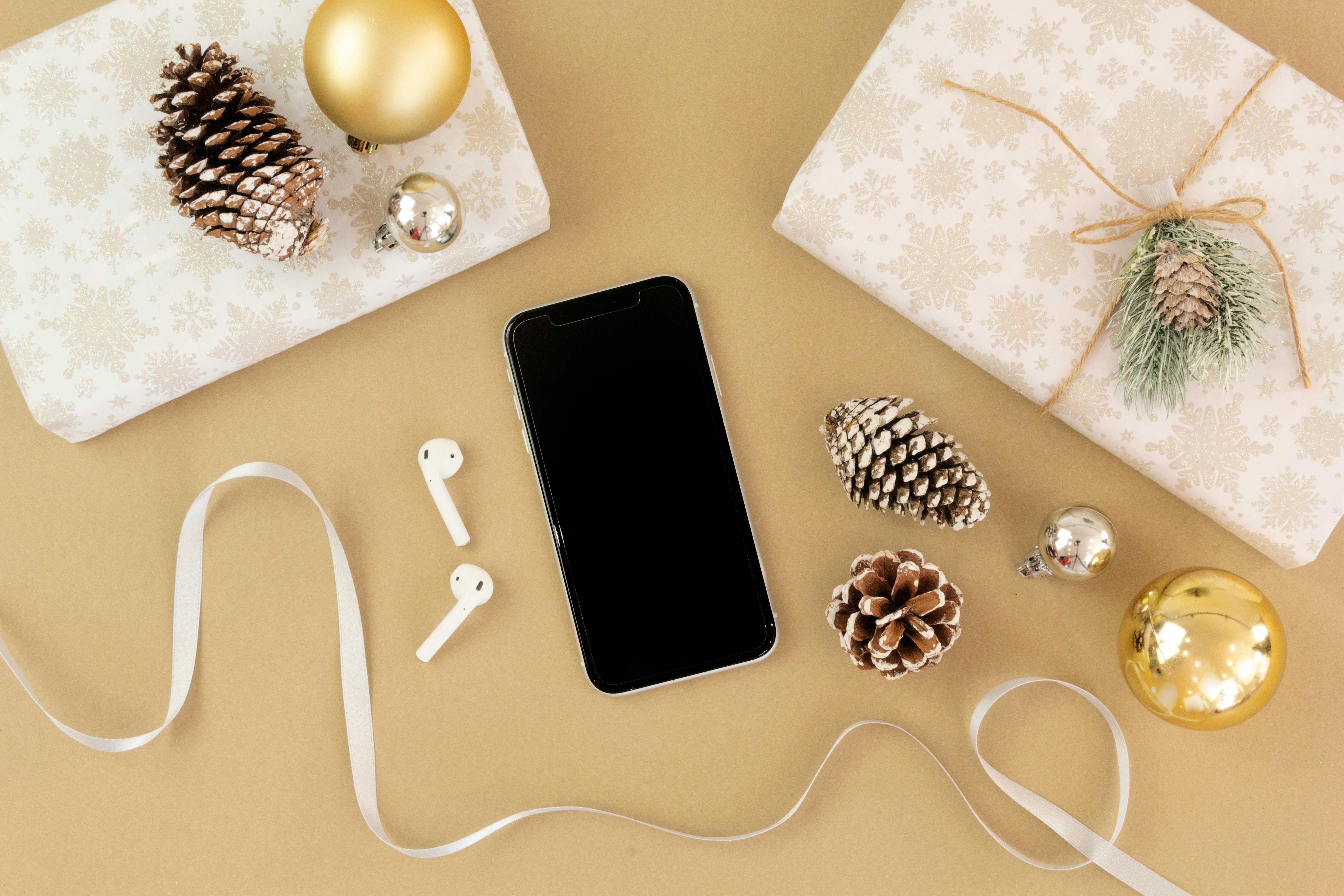 flat lay photography of android smartphone and airpods decorations teams background
