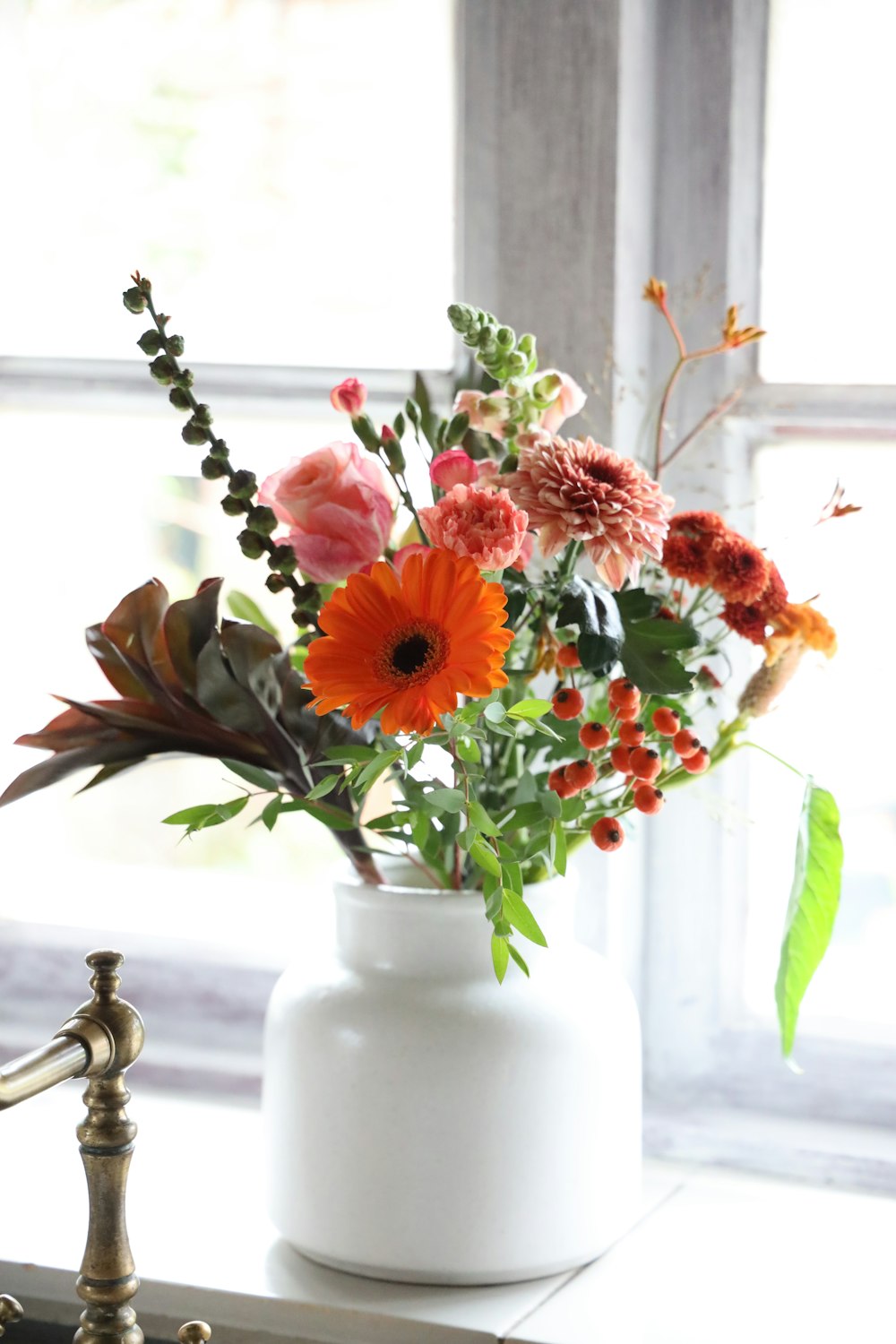 flower arrangement in vase on window