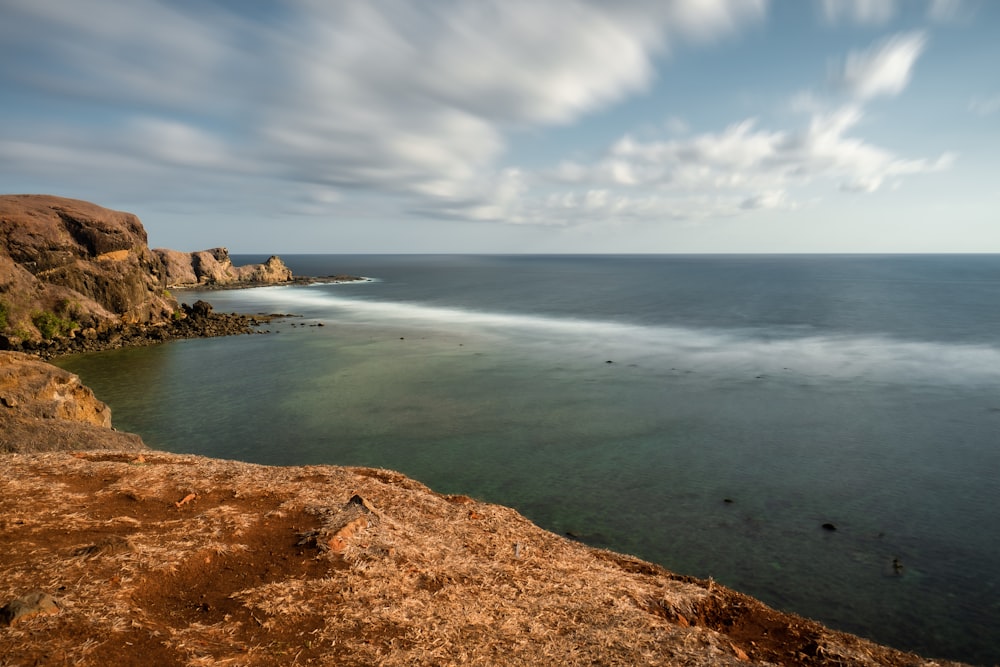 cliff beside body of water