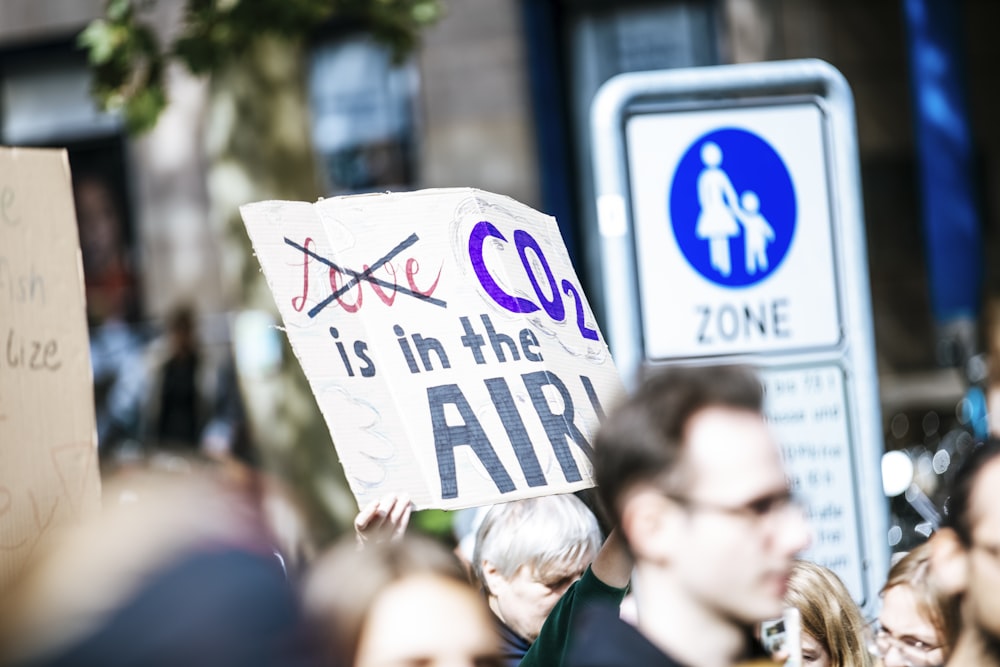 shallow focus photo of person holding signage