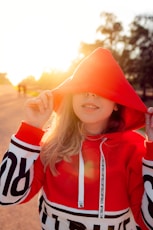 woman wearing red and white pullover hoodie during sunrise