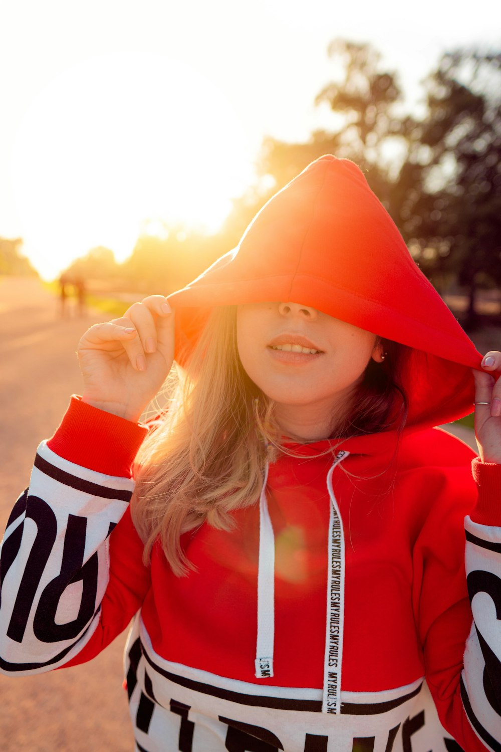 femme portant un sweat à capuche rouge et blanc au lever du soleil