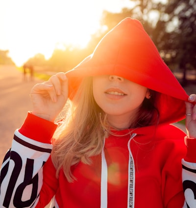 woman wearing red and white pullover hoodie during sunrise