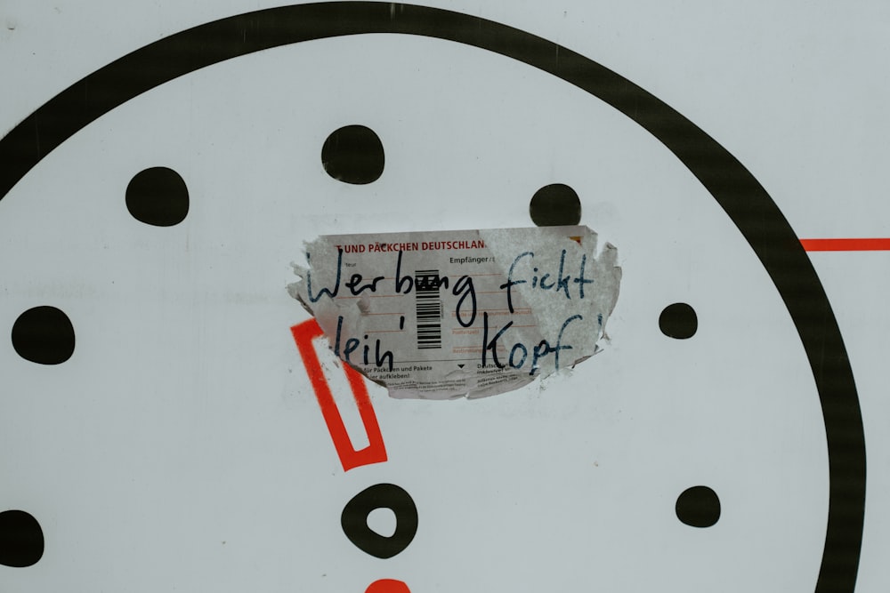a close up of a clock with a piece of paper on it