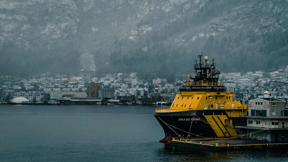 yellow and black boat in dock near mountain