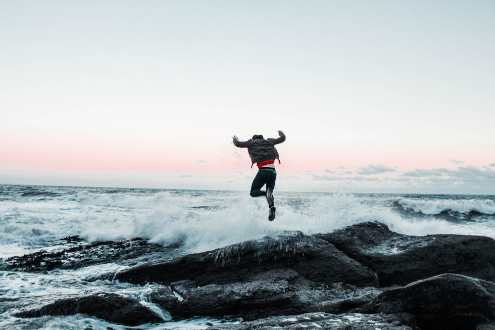 man jumping on rock