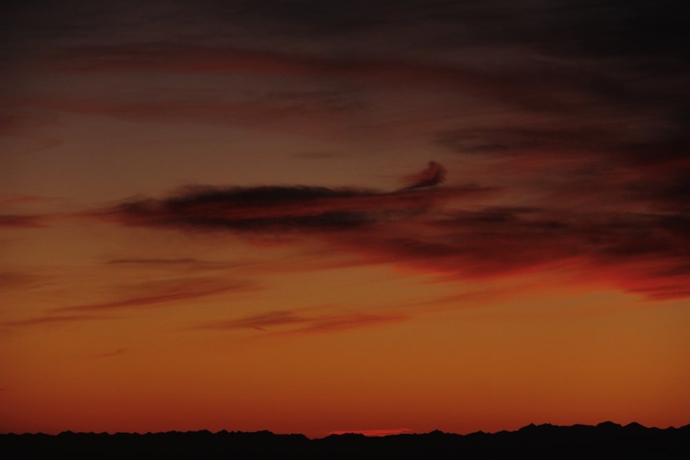 a plane is flying in the sky at sunset