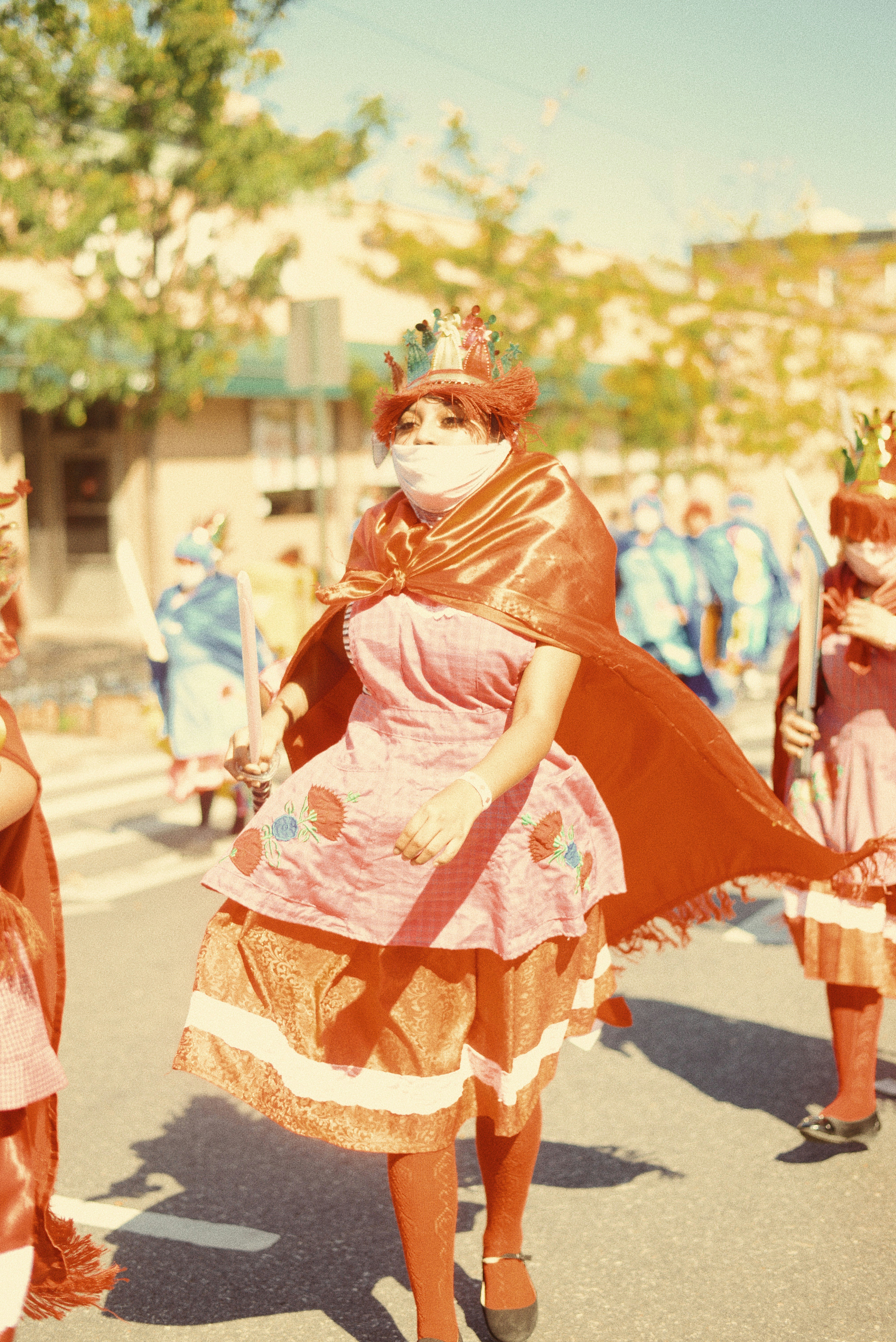 Foto fokus dangkal wanita dengan gaun merah muda mengenakan jubah coklat
