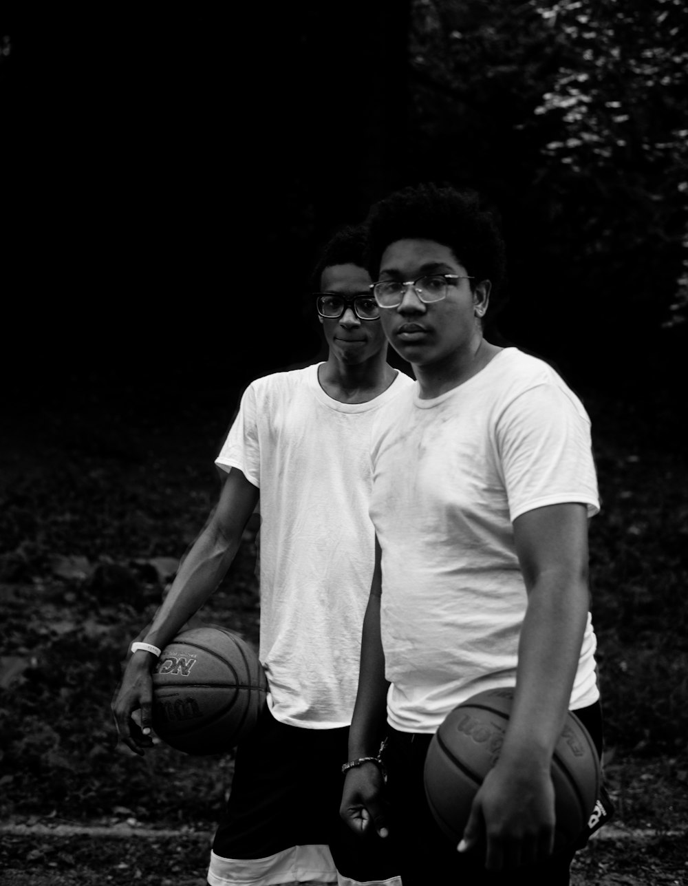 grayscale photography of two man in shirts holding basketball