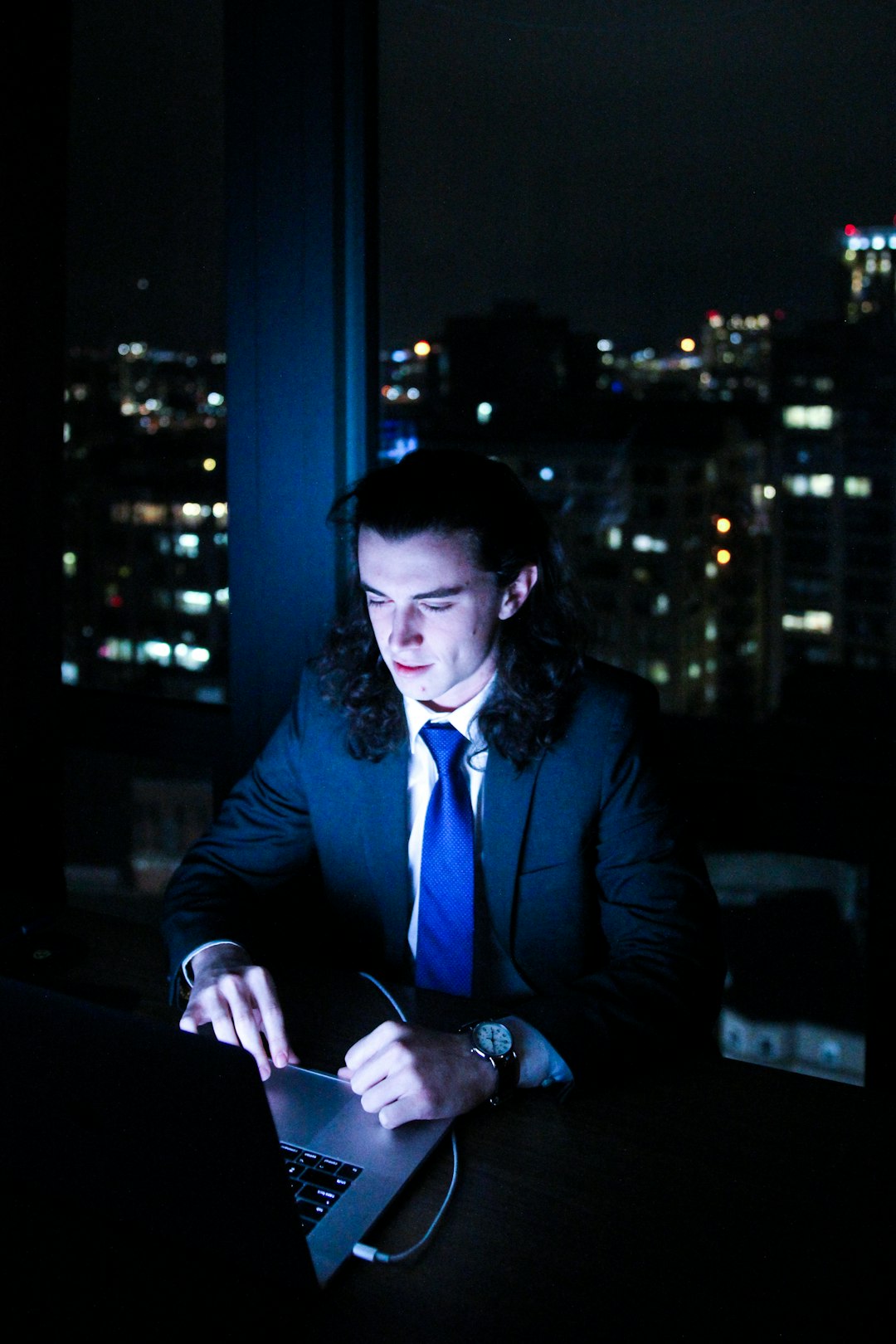 man in suit using laptop