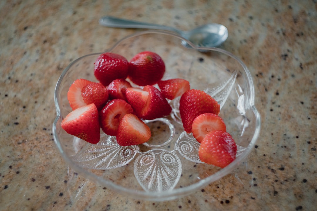 sliced strawberries in saucer beside spoon
