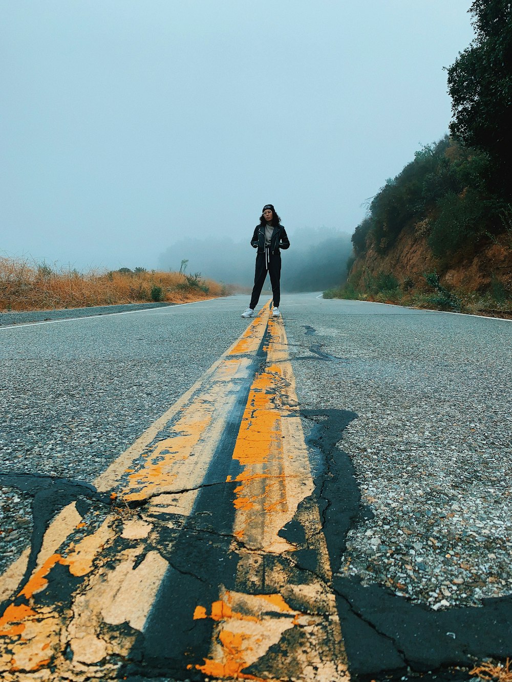 woman standing on center of road during daytime