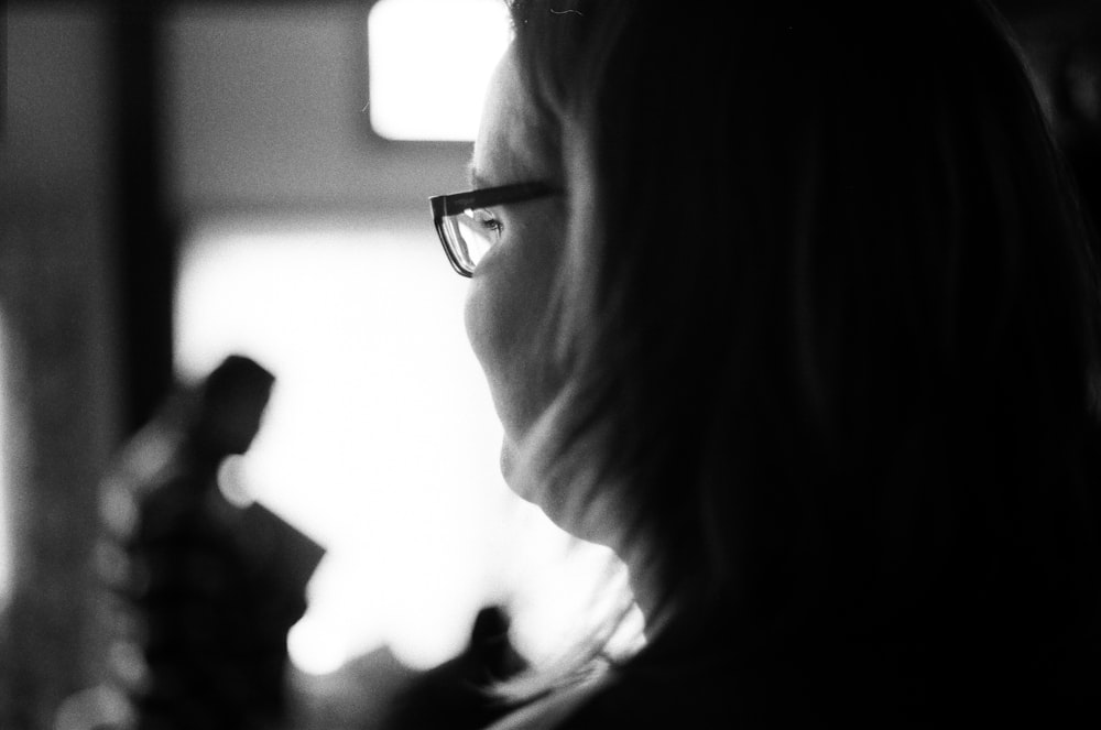 a black and white photo of a woman wearing glasses