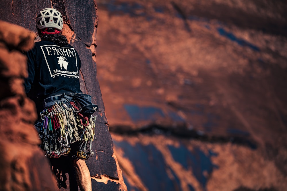 man climbing on rock with gears