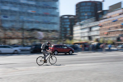 A cyclist in motion through city streets, sporting qam’s streamlined, functional apparel.