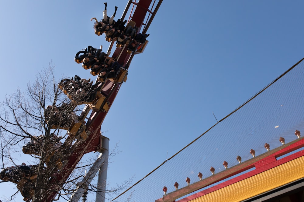 people riding roller coaster during daytime