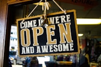 people inside building with come in we're open and awesome sign