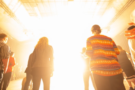A diverse group of people wearing various styles of clothing in a bright setting.